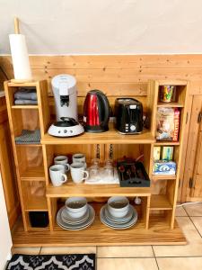 une étagère en bois avec des tasses et des appareils dans l'établissement Charmant appart sous toits proche Château des Ducs, à Chambéry