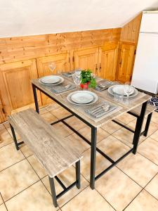 une table en bois avec deux assiettes et deux chaises dans l'établissement Charmant appart sous toits proche Château des Ducs, à Chambéry