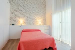 - une chambre avec un lit et un mur en briques dans l'établissement HoneyMoon Apartment, à Séville