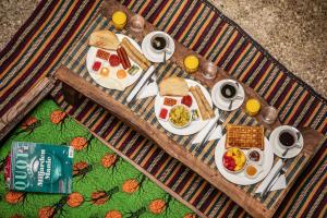 a breakfast table with eggs and bread and orange juice at Shoki Shoki House Stone Town in Zanzibar City