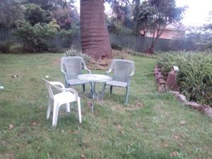 3 sillas y una mesa en un patio en Sylvia Lodge A step back in time pet friendly Homestay en Orbost