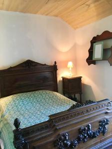 sypialnia z drewnianym łóżkiem i stołem z lampką w obiekcie Maison de 4 chambres avec jardin amenage a Naucelles 