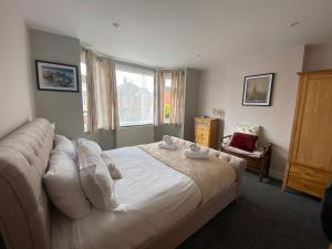 a bedroom with a bed and a couch and a window at Charming 3 bed house and garden, pet friendly in Bournemouth