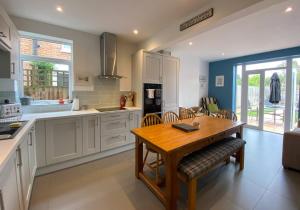 a kitchen with a wooden table and a dining room at Charming 3 bed house and garden, pet friendly in Bournemouth