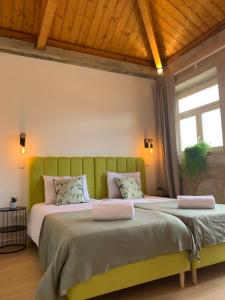 two beds in a bedroom with a green headboard at Lost Inn Porto Hostel in Porto