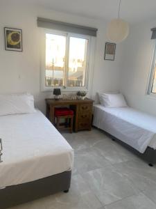 1 dormitorio con 2 camas, escritorio y ventana en Player Sea View apartment en Pafos