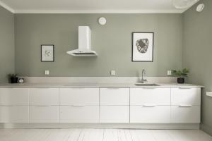 a kitchen with white cabinets and a sink at Prestige City Home in Helsinki