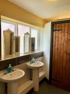 a bathroom with two sinks and two windows at Valley Farm Bells in Oxford