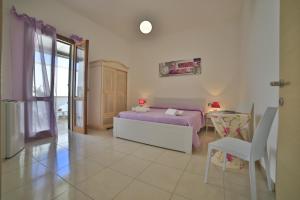 a bedroom with a bed and a table in it at Meraviglie del Salento in Porto Cesareo