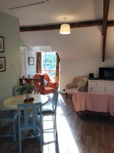 a kitchen and living room with a table and chairs at The Hayloft in Abergavenny
