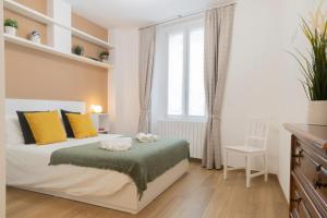 um quarto com uma cama com almofadas amarelas e uma janela em Brilla [Marvelous apartment in the center] Bergamo em Bérgamo