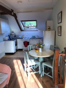a kitchen with a table and chairs and a refrigerator at The Hayloft in Abergavenny