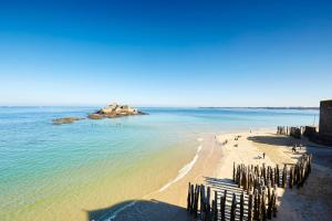a beach with a group of people and the ocean at Le Bigorneau , beach at 20m and free private carpark in Saint Malo