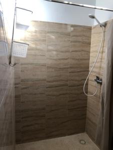 a bathroom with a shower with a wooden wall at La Maison Aziz - Somone / Sénégal in Somone +13 photos