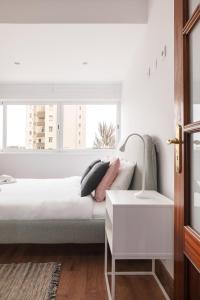 una camera bianca con un letto e una finestra di Equador Apartments by Olala Homes a Cascais