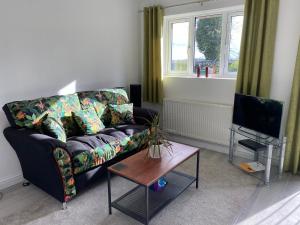 a living room with a couch and a table and a tv at The Norton-Triumpth Apartments near NEC in Meriden