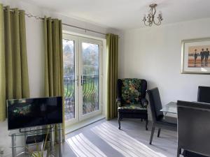 a living room with a tv and a chair and a window at The Norton-Triumpth Apartments near NEC in Meriden