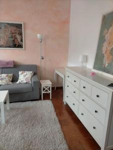 ein Wohnzimmer mit einer weißen Kommode und einer Couch in der Unterkunft Schönes Altstadt-Apartment ''Dolce Vita'' inkl Parkplatz in Riva del Garda
