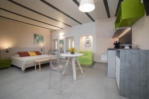 een kamer met een bed, een tafel en een keuken bij Le Case di Angelina - Langhe Loft & Suites in Farigliano