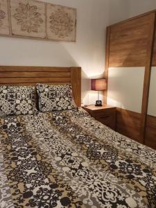 1 dormitorio con 1 cama grande y cabecero de madera en CAMPANUCA, en Unquera