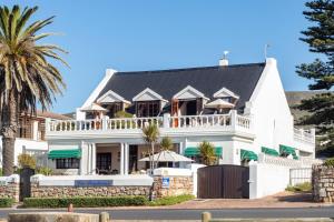 a large white house with a black roof at La Fontaine Guest House Hermanus in Hermanus