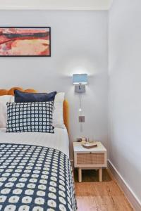 a bedroom with a bed and a side table at Cleveland Street by Q Apartments in London