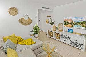 uma sala de estar com um sofá e uma televisão em Vista Melaleuca - Drift 2409 em Palm Cove