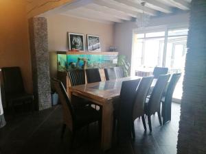 una sala da pranzo con tavolo, sedie e acquario di Villa élégante à Saint Clair-d'Arcey avec piscine privée a Bernay