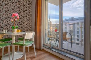 una stanza con tavolo, sedie e balcone di Langgarten Apartments by Little Heaven a Danzica