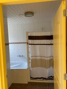 bagno con vasca e tenda doccia di de Zandput 46 a Zoutelande