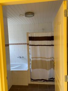 a bathroom with a tub and a shower curtain at de Zandput 46 in Zoutelande
