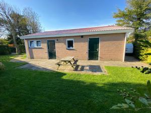 a small brick house with a picnic table in front of it at de Zandput 46 in Zoutelande