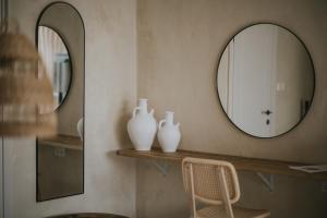 two white vases on a shelf next to a mirror at Hotel Anilevich Mansion in Beer Sheva
