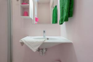 a white sink in a bathroom with green towels at Casa Diaz in Cagliari