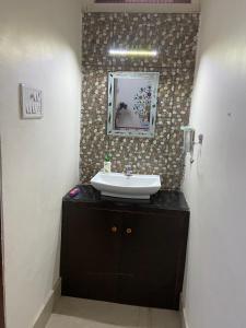 Golden Peacock Heritage Home Stay في جايبور: حمام مع حوض ومرآة