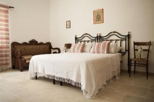 a bedroom with a bed with white sheets and pillows at Il Trullo Bianco a Masseria Santalachicca in Masseria Orimini