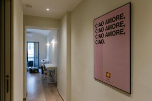 a room with a poster on the wall and a hallway at Tomato Urban Retreat in Turin