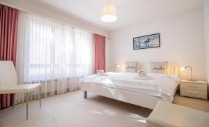 Un dormitorio blanco con una cama grande y una ventana. en Gentiana B2 by Arosa Holiday, en Arosa
