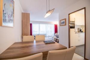 Una cocina y un comedor con mesa y sillas de madera. en Gentiana B2 by Arosa Holiday, en Arosa 10 fotos más