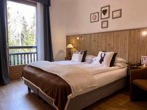 1 dormitorio con 1 cama grande y ventana grande en Hotel Derby, en Folgarida