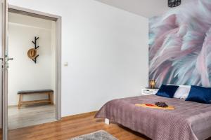 a bedroom with a bed with a painting on the wall at Apartamenty Niko in Zator