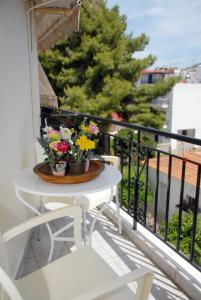 una mesa blanca con flores en el balcón en Tzovanna Studios, en Loutra Edipsou