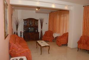 uma sala de estar com mobiliário laranja e cadeiras laranja em Tzovanna Studios em Loutra Edipsou