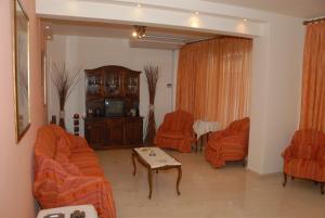 a living room with orange furniture and orange chairs at Tzovanna Studios in Loutra Edipsou