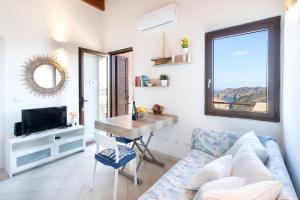 SEA VIEW HOUSE - STINTINO في بالمادولا: غرفة معيشة مع أريكة وطاولة وتلفزيون