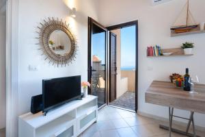 SEA VIEW HOUSE - STINTINO في بالمادولا: غرفة معيشة مع تلفزيون ومرآة