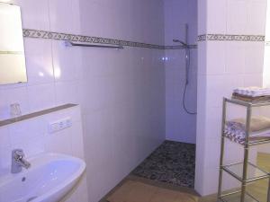 a white bathroom with a shower and a sink at Gästehaus Weissenbauer in Lenggries