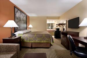 a hotel room with a bed and a desk at Super 8 by Wyndham Ruston in Ruston
