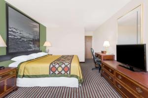 a hotel room with a bed and a flat screen tv at Super 8 by Wyndham Lexington in Lexington