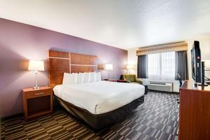 Habitación de hotel con cama grande y TV en Best Western Firestone Inn & Suites, en Longmont